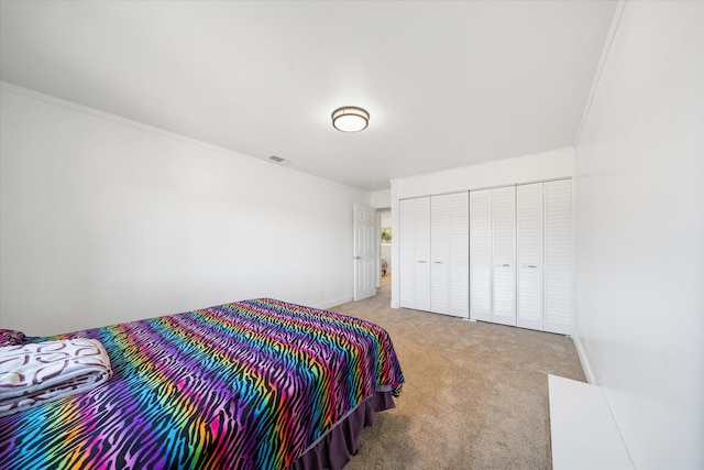 carpeted bedroom featuring crown molding and a closet