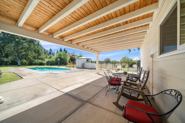 view of patio / terrace featuring a storage unit and a fenced in pool