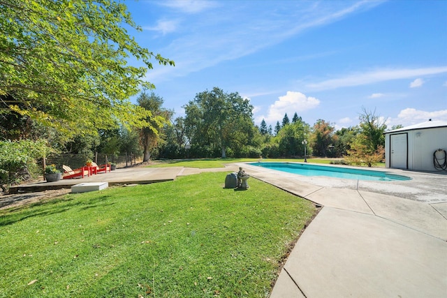 view of swimming pool with a lawn, a patio area, and a shed