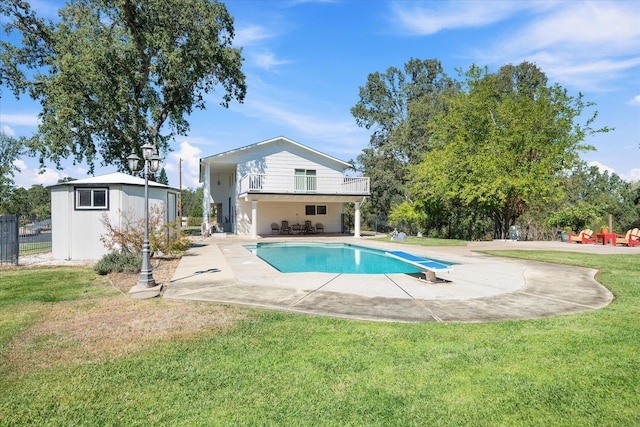 view of swimming pool featuring a diving board, a lawn, and a patio