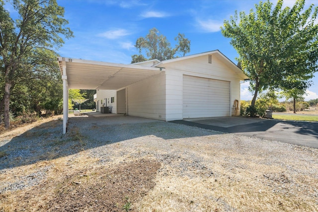 garage with a carport and central air condition unit