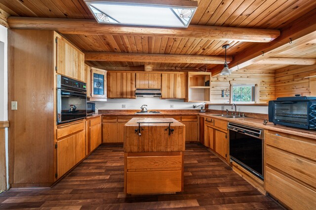 kitchen featuring a center island, dark wood-type flooring, beam ceiling, black appliances, and a skylight