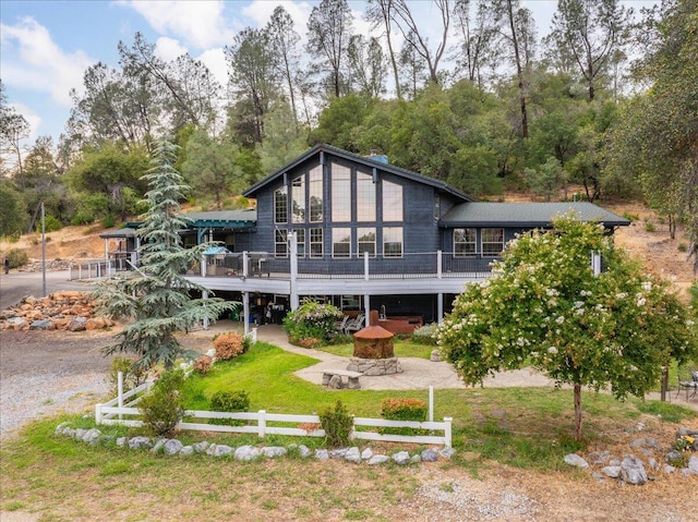 rear view of property featuring a lawn, a patio area, and a deck