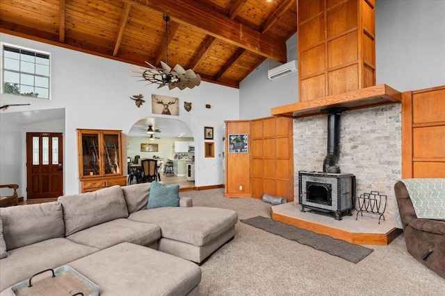 carpeted living room with ceiling fan, beam ceiling, a wood stove, high vaulted ceiling, and wooden ceiling