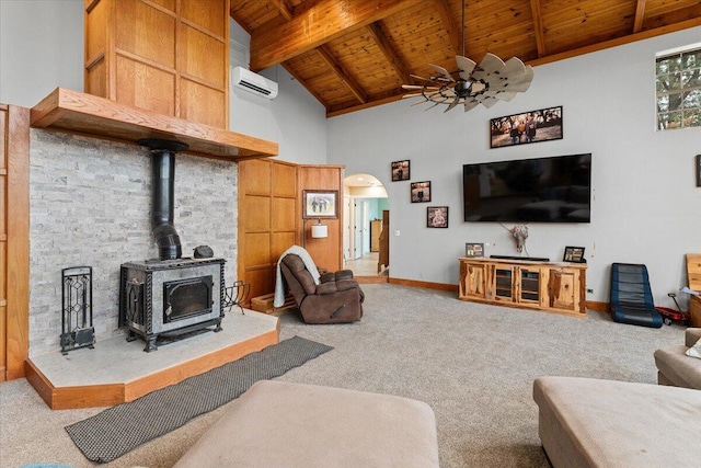 carpeted living room featuring wood ceiling, an AC wall unit, a wood stove, high vaulted ceiling, and ceiling fan