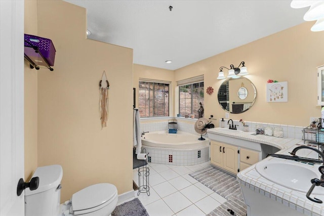 bathroom with tile patterned flooring, vanity, toilet, and a relaxing tiled tub