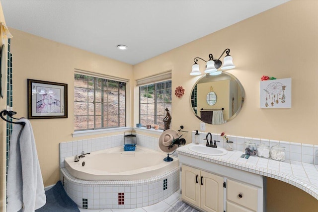 bathroom featuring vanity and a relaxing tiled tub