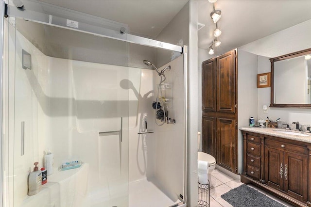 bathroom with vanity, tile patterned floors, a shower with shower door, and toilet