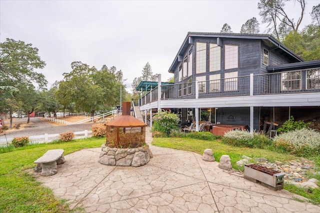 back of property featuring a deck, a yard, and a patio area