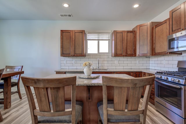 3554 Cazadero Dr, Anderson, CA 96007 - kitchen with a center island, a sink, tasteful backsplash, visible vents, and appliances with stainless steel finishes