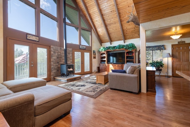 living room featuring wood ceiling, hardwood / wood-style floors, high vaulted ceiling, beamed ceiling, and a wood stove