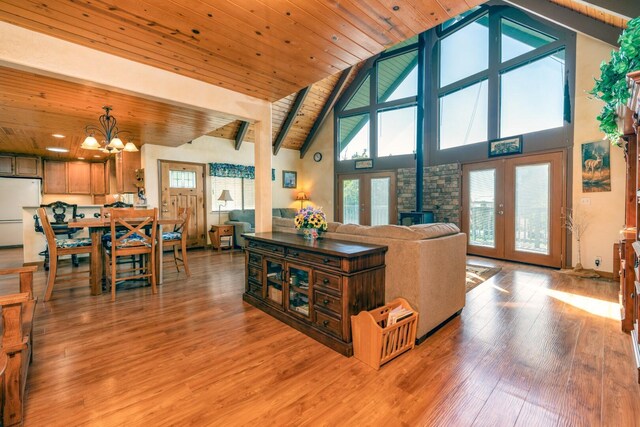 living room with french doors, wood ceiling, beam ceiling, high vaulted ceiling, and light hardwood / wood-style flooring