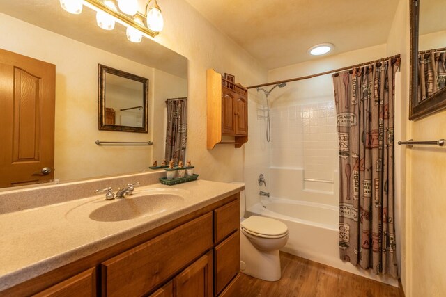 full bathroom with toilet, vanity, wood-type flooring, and shower / tub combo