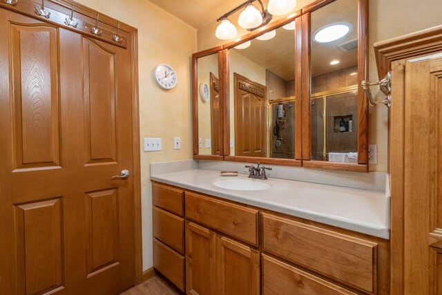 bathroom with vanity and a shower with door