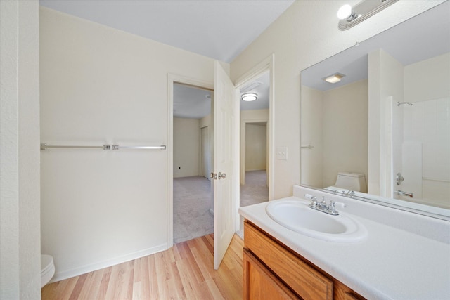 full bathroom with wood-type flooring,  shower combination, vanity, and toilet