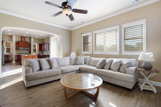 living room featuring ceiling fan, crown molding, and dark wood-type flooring