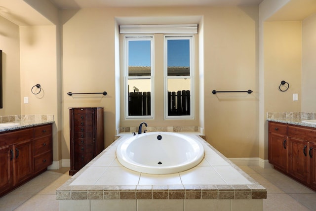 bathroom featuring vanity, tile patterned floors, and a relaxing tiled tub