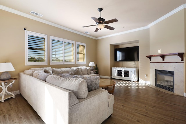 living room with ornamental molding, ceiling fan, a tile fireplace, and dark hardwood / wood-style floors