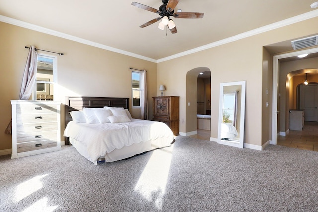 carpeted bedroom featuring ensuite bath, ceiling fan, and crown molding