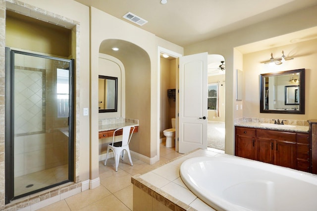 full bathroom with vanity, tile patterned flooring, ceiling fan, shower with separate bathtub, and toilet