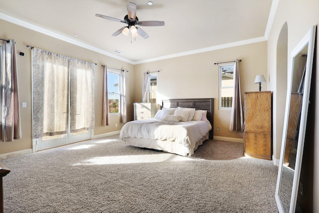 carpeted bedroom featuring ceiling fan and crown molding