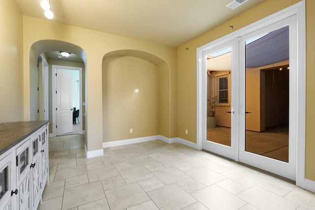 empty room with french doors and light tile patterned floors