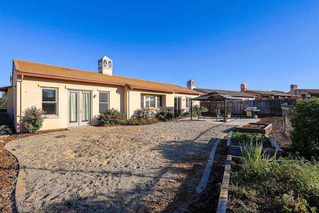 back of property with french doors, a patio, and a gazebo