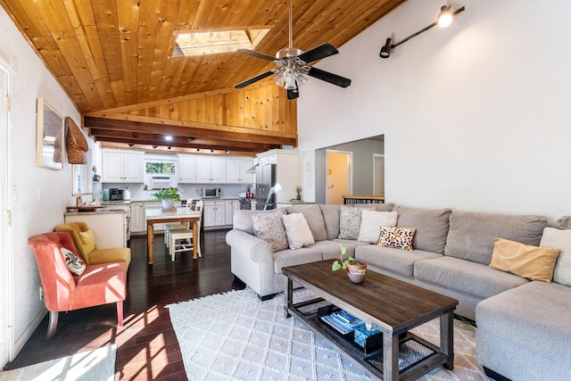 living room with wood ceiling, dark hardwood / wood-style floors, high vaulted ceiling, a skylight, and ceiling fan