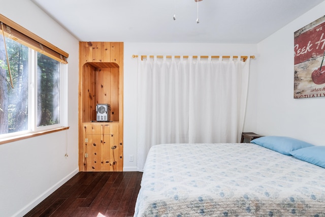 bedroom with dark wood-type flooring and multiple windows