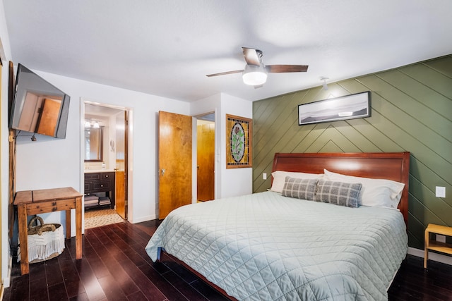 bedroom with ceiling fan, hardwood / wood-style flooring, ensuite bath, and wood walls