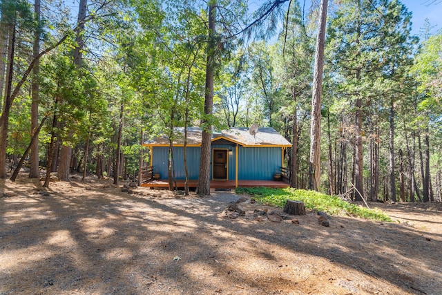 30570 Sleepy Hollow Dr, Shingletown, CA 96088 - view of front of property featuring a deck, an outdoor structure, a forest view, and a chimney