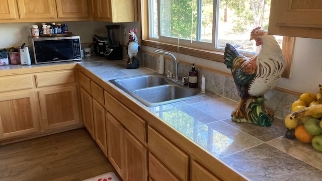 kitchen with tile countertops, light hardwood / wood-style flooring, and sink