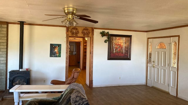 dining space with dark wood-type flooring, ceiling fan, crown molding, and a wood stove