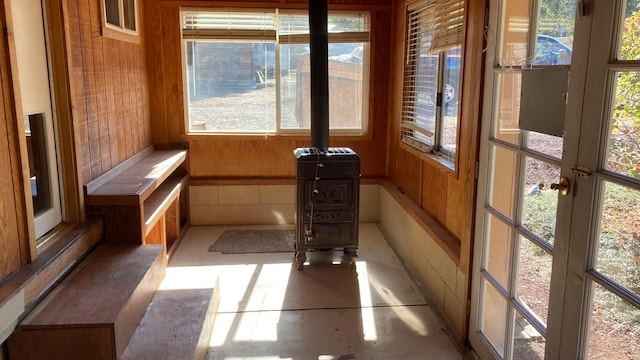 unfurnished sunroom featuring a wood stove