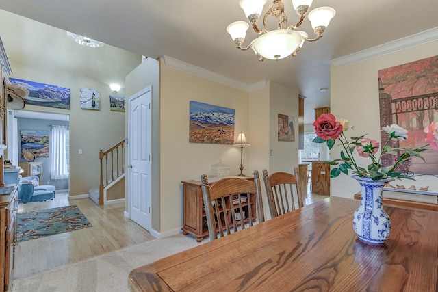 dining space featuring a notable chandelier, light hardwood / wood-style flooring, crown molding, and a healthy amount of sunlight