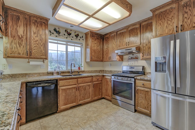 kitchen with light stone counters, appliances with stainless steel finishes, and sink