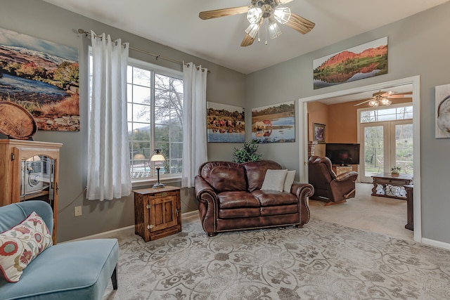 living area with light carpet, ceiling fan, and plenty of natural light