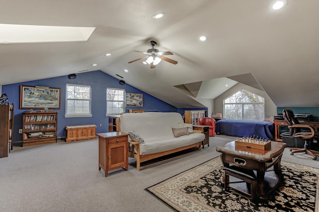 carpeted bedroom featuring lofted ceiling with skylight and ceiling fan