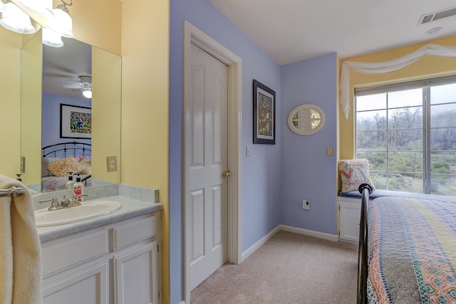 carpeted bedroom with ceiling fan and sink