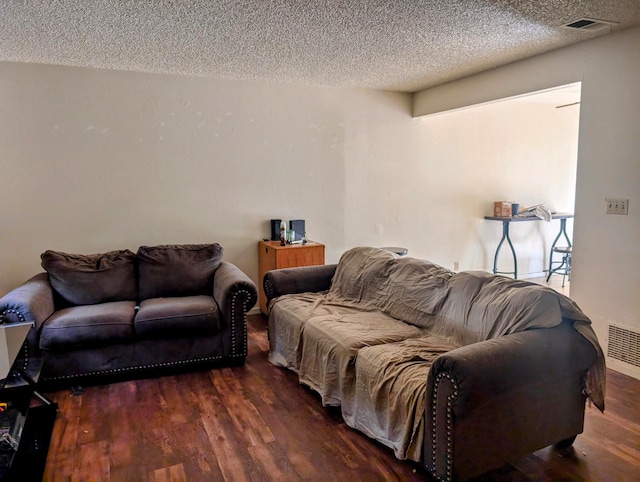 living room featuring dark hardwood / wood-style floors and a textured ceiling