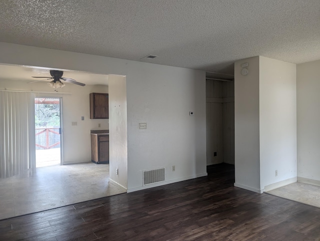 spare room with dark hardwood / wood-style flooring, ceiling fan, and a textured ceiling