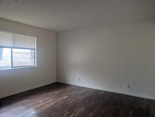 empty room featuring dark hardwood / wood-style flooring and a textured ceiling