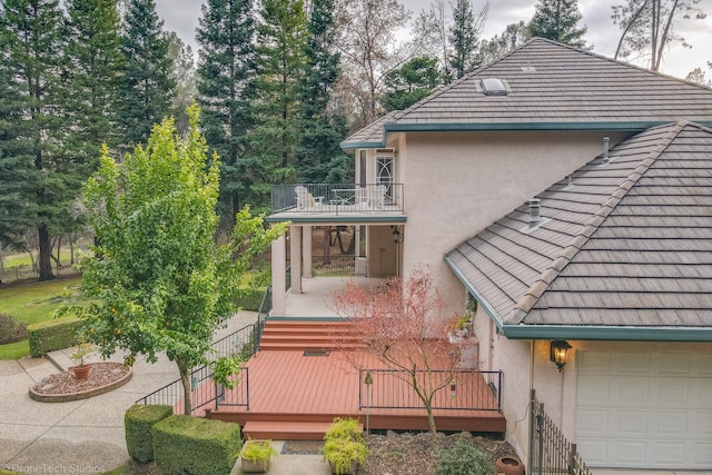 view of side of home featuring a balcony and a garage