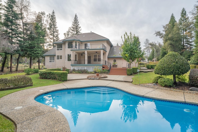 back of property with a balcony and a yard