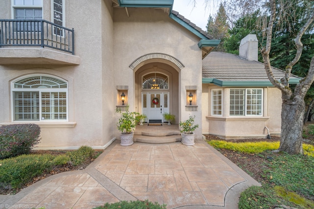 view of exterior entry featuring a balcony