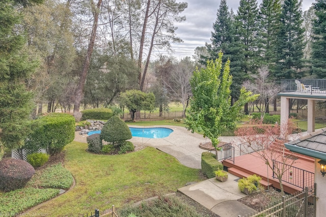 view of pool with a deck and a yard