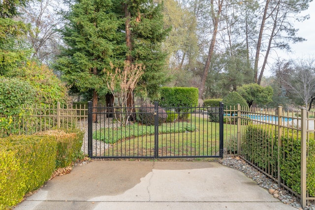 view of gate with a lawn and a fenced in pool