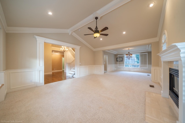 unfurnished living room with a tile fireplace, ornamental molding, lofted ceiling with beams, and light carpet