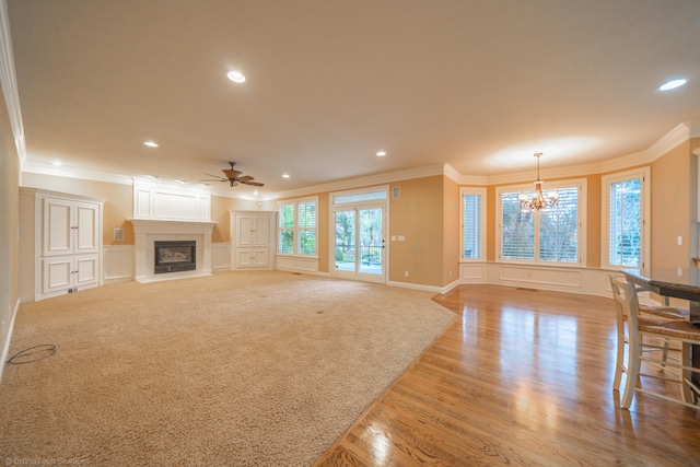 living room featuring light hardwood / wood-style flooring, ceiling fan with notable chandelier, and crown molding