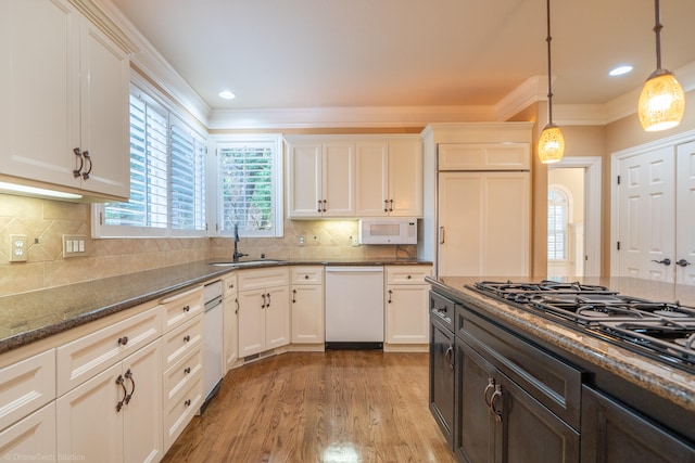 kitchen featuring white appliances, white cabinetry, dark stone countertops, and pendant lighting